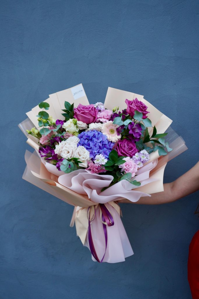 Buchet de flori elegante cu hortensie mov, trandafiri și lisianthus